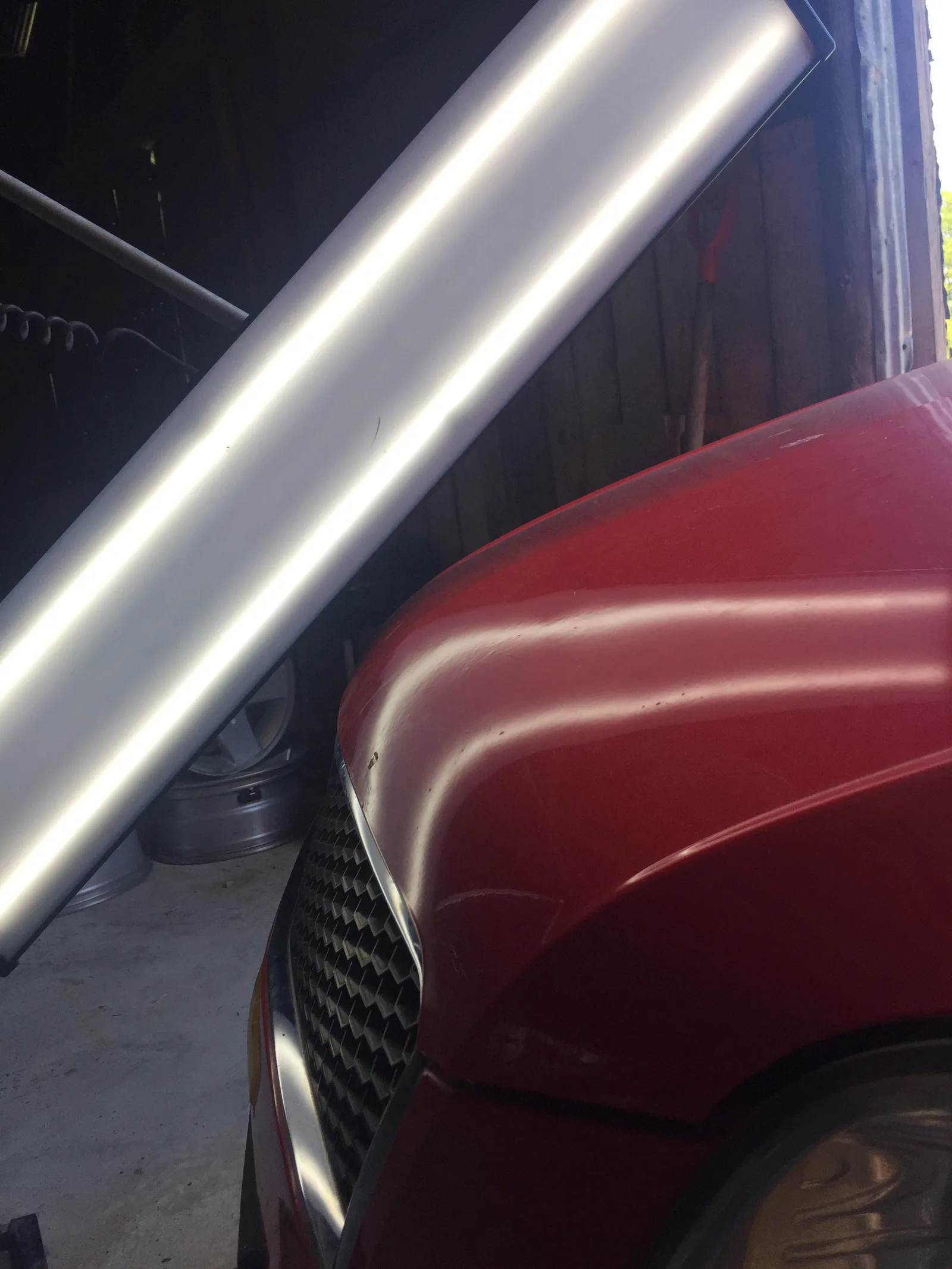 After PDR repair — hood crease fully removed on red vehicle