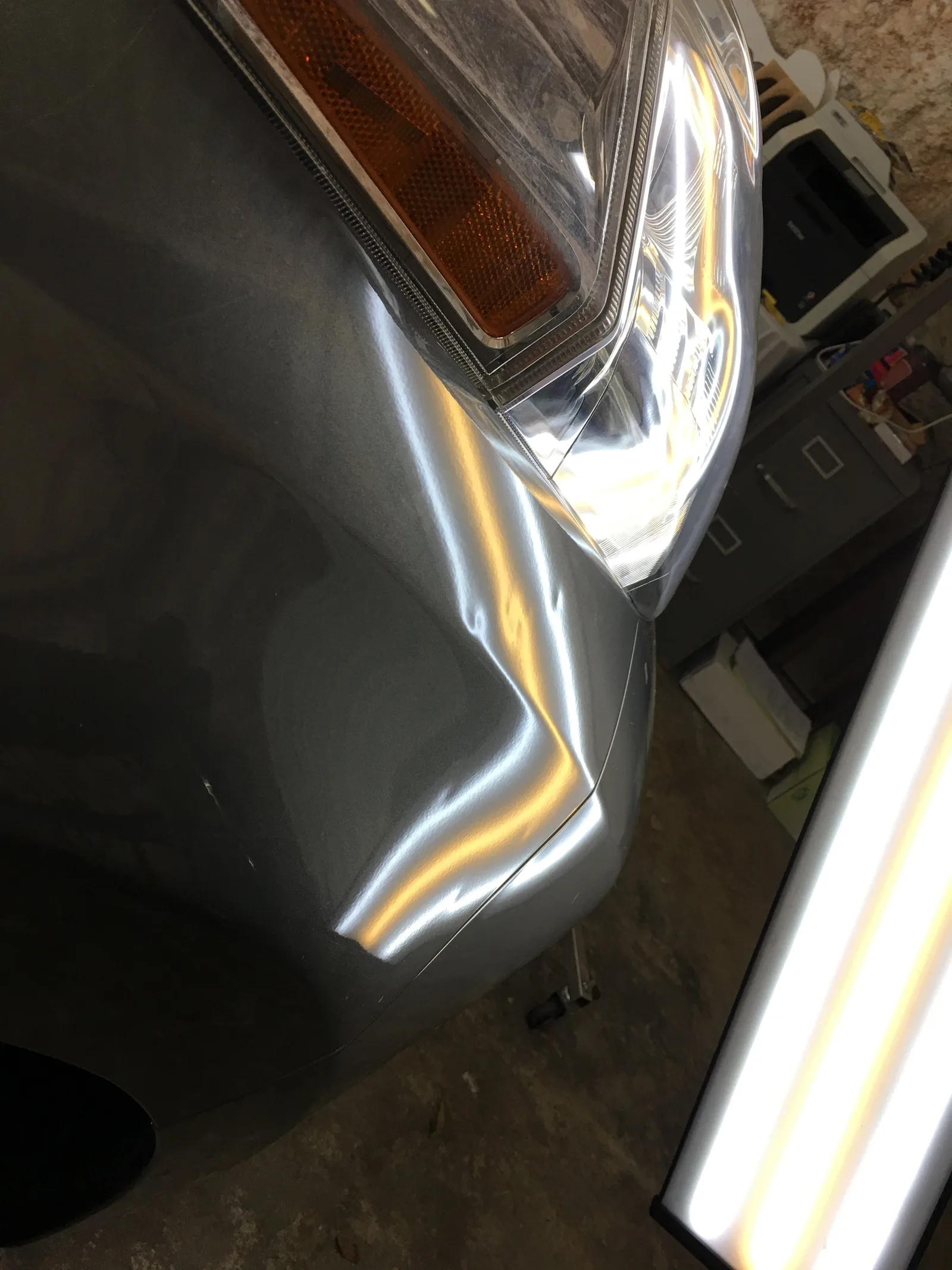 Before PDR repair — significant crease on gray vehicle fender