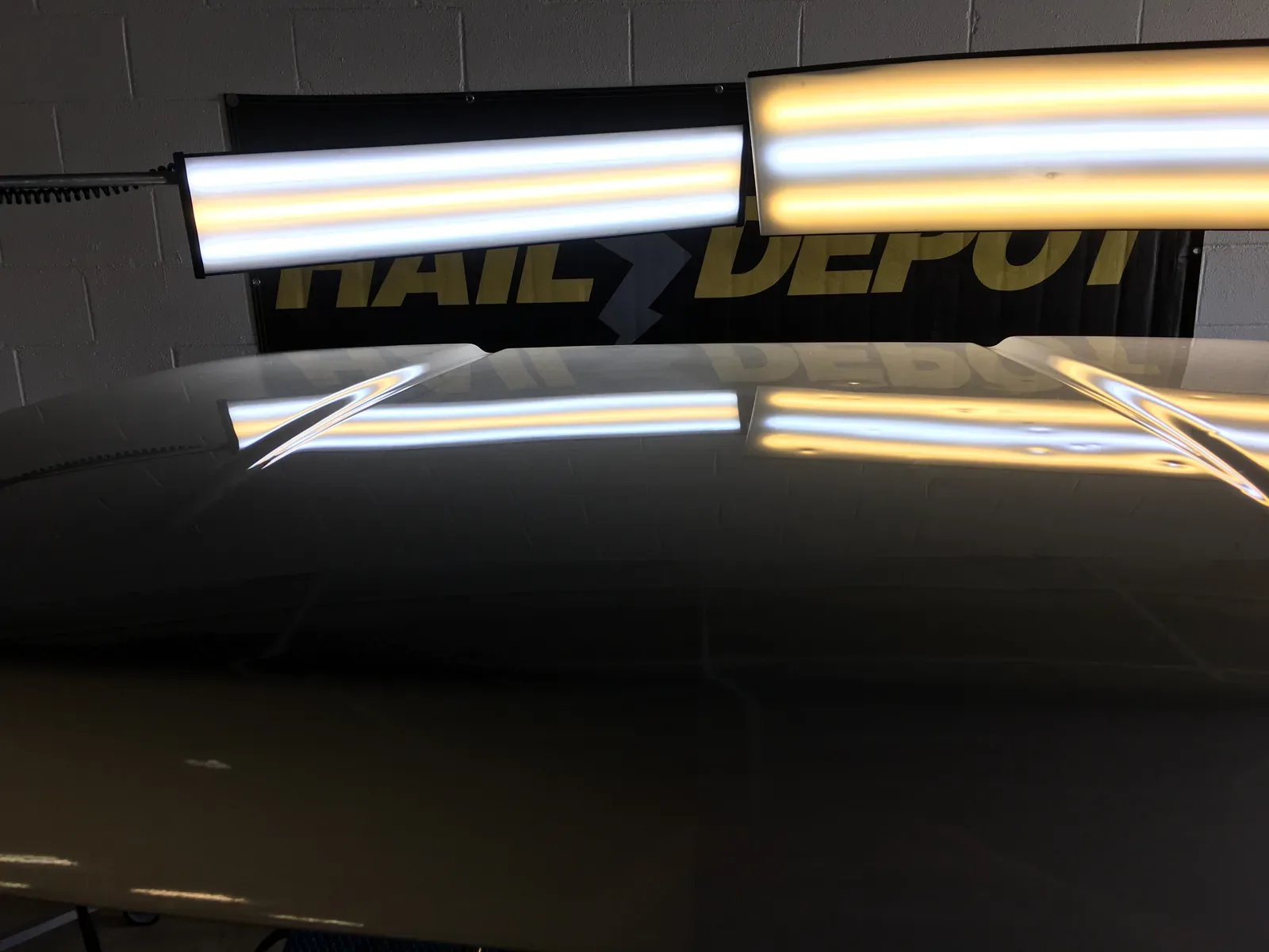 Clean panel after PDR repair with the Hail Depot banner in the background